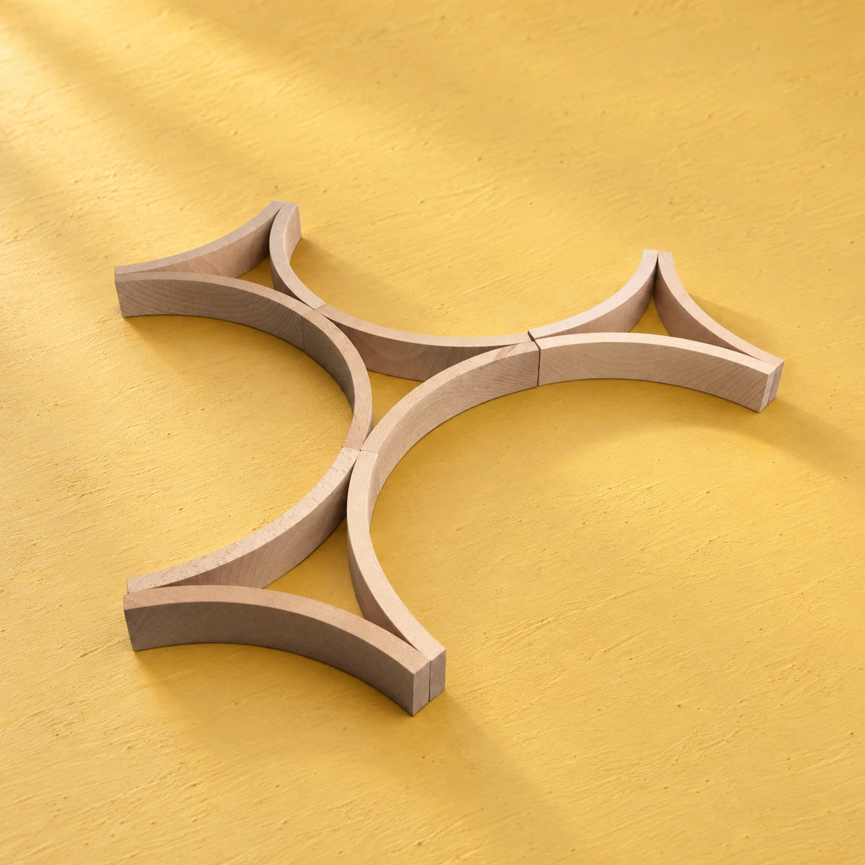 Twelve full-size curved Abel blocks on a warm yellow surface