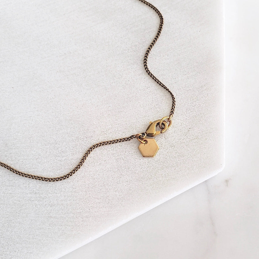 Antiqued chain clasp and charm detail
