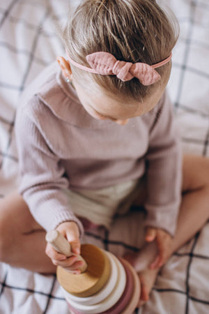 Child stacking the SABO wooden ring stacker