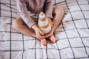 Child sitting with the stacked SABO wooden ring stacker