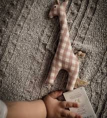Child holding the beige plaid Senger Grabber Giraffe