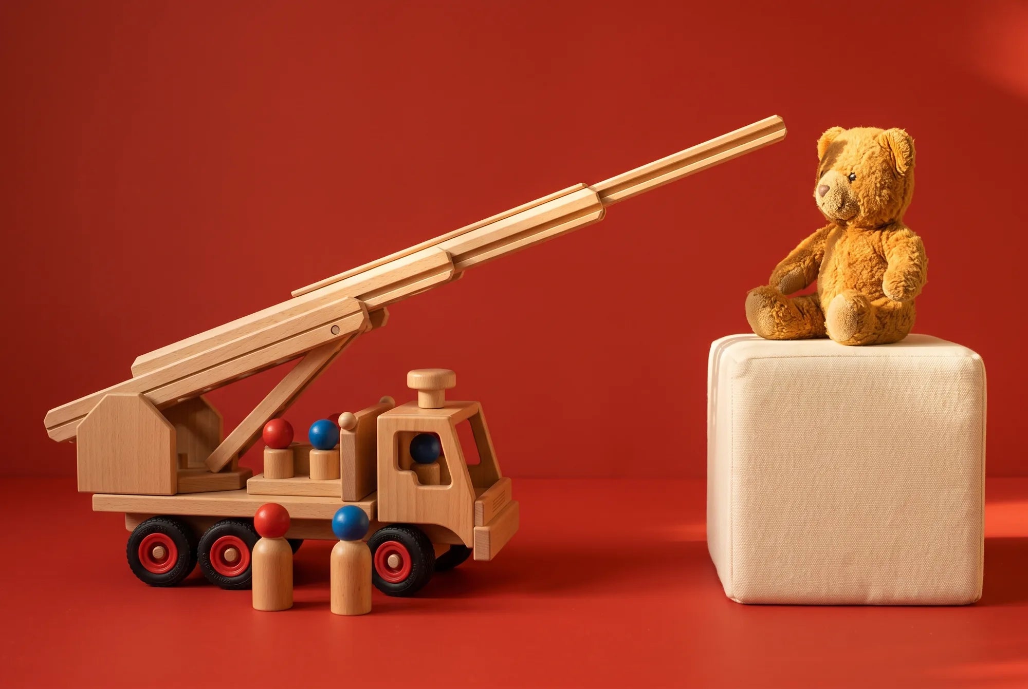 The Fagus Fire Engine with its ladder raised toward a teddy bear on a cushion