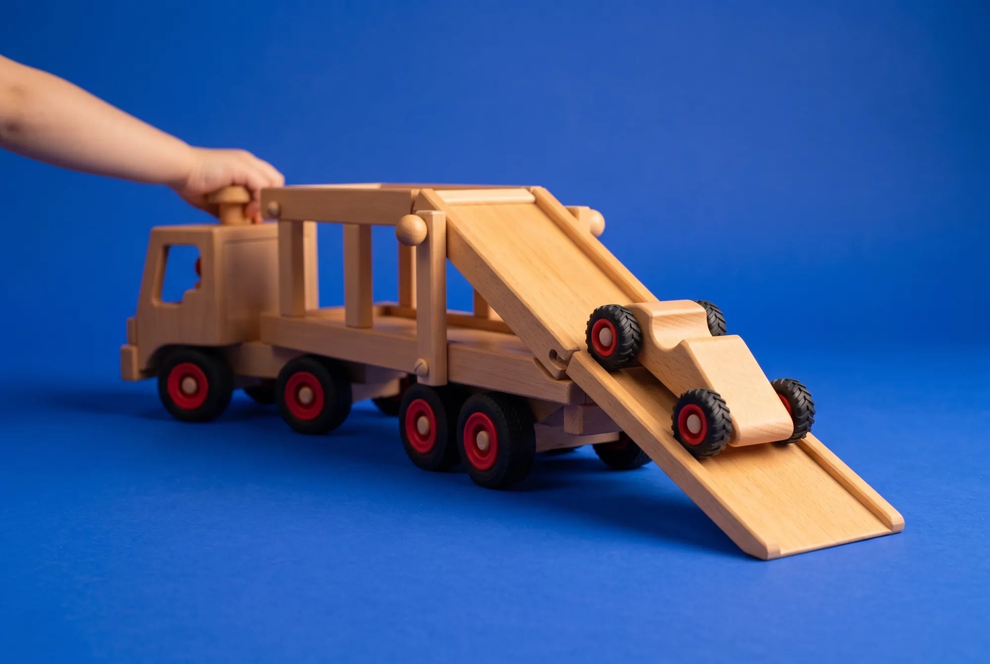 A child steering the Fagus Car Transporter as a Speedy car rolls down its ramp