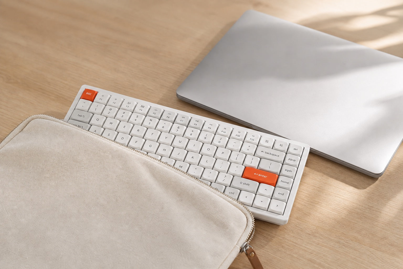 The K2 Max half-slid into a canvas sleeve beside a laptop — ready to leave.