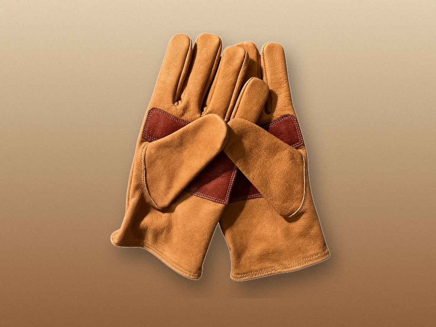 Actual product pair showing all-tan leather fingertips and oxblood palm reinforcement
