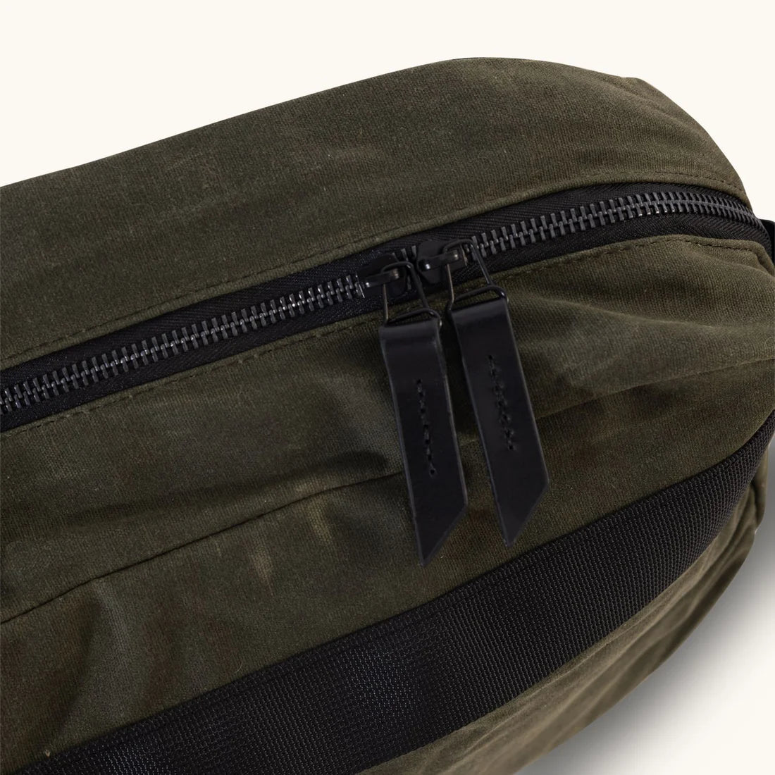 Close view of the waxed canvas and two-way zipper
