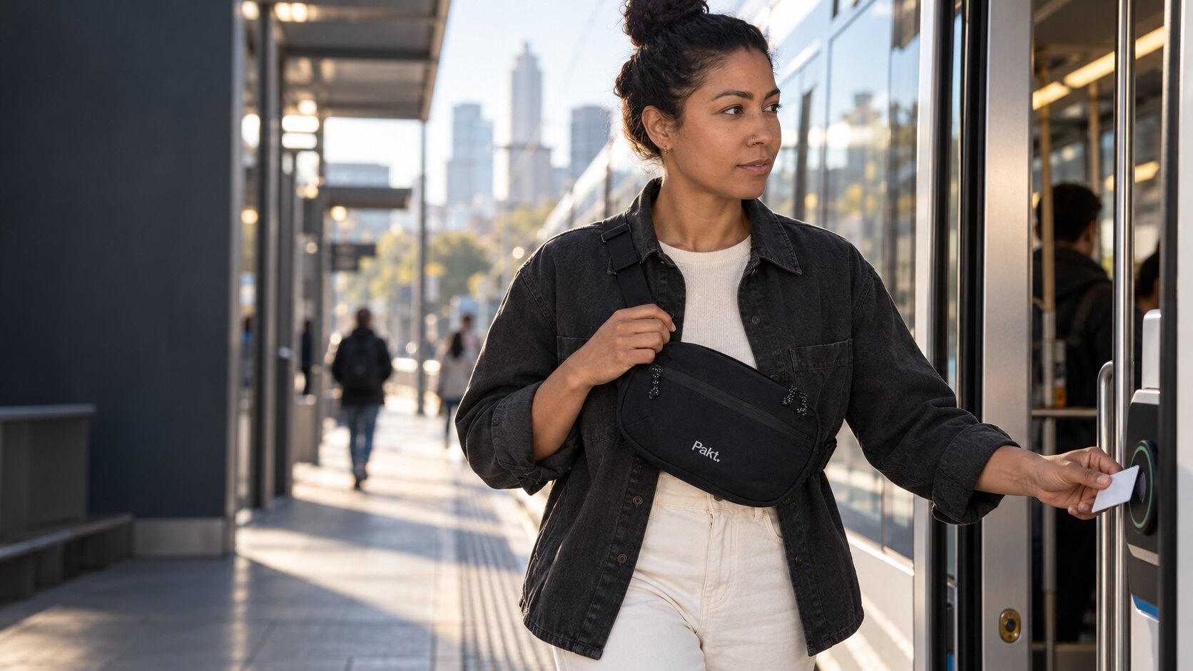 Traveler wearing the black Pakt Everyday 3L Sling while boarding a city tram
